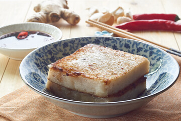 radish cake, turnip cake, daikon cake, wooden table, sauce chopsticks, steamer