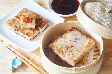 radish cake, turnip cake, daikon cake, wooden table, sauce chopsticks, steamer