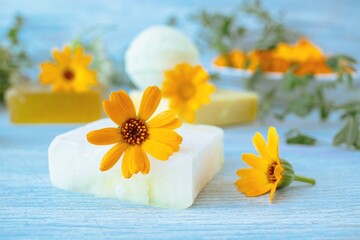 Fototapeta na wymiar Soap with calendula, fresh flowers and useful plants, on a wooden background, natural cosmetics, body care and bath products
