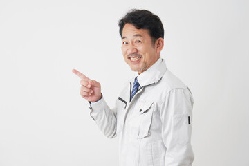 左側を指差すミドルエイジの作業員　白背景