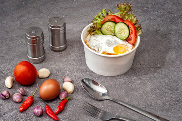 Posiłek na stole składający się z dania na wynos: rice bowl z ryżem, jajkiem i warzywami - obrazy, fototapety, plakaty