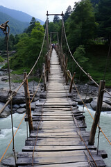 A suspension bridge over the river was built with wooden material