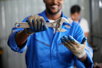 closeup worker or technician hands holding wrench and fist bump pose in the factory