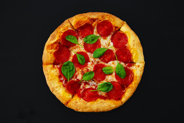 Fresh pepperoni pizza on a black background.