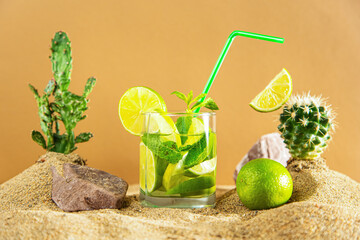 Glass of lemonade with lime and mint among the sand dunes and cacti.