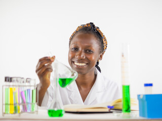  Young female scientist keenly observing a sample in an erlenmeyer flask inside a laboratory...