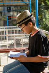 a boys reading the book in a street with a special interest