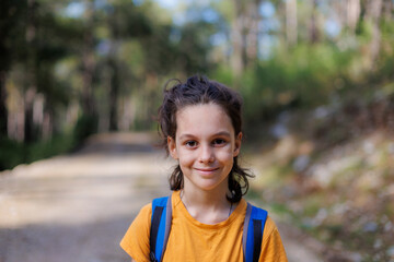 portrait of a child with a backpack outside the city. a boy with a backpack travels.