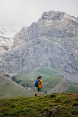 Fototapeta na wymiar boy with a backpack on a hike against the backdrop of the mountains. child traveler with backpack, hiking, travel, mountains in the background, kids summer vacation.