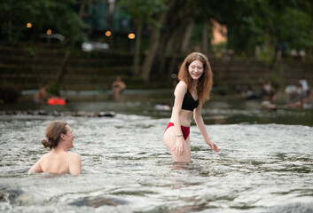 Young couple having fun in the water of a river on a hot summer day
