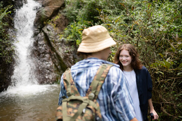 Young couple of hikers sitting on a rock and looking at each other