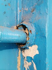 Blue Old Pipe enters blue wall. Building wall includes steel pipe. Gas equipment Part. Wall angle....