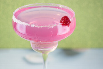 Raspberry daiquiri cocktail on a green background.