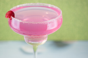 Raspberry daiquiri cocktail on a green background.