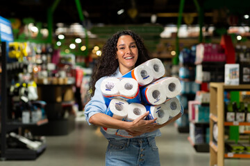 Happy woman shopper smiling bought many rolls of toilet paper in supermarket.