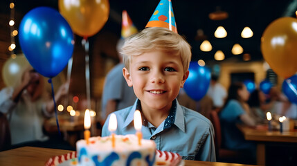 Happy adorable boy smiling and celebrating his birthday, portrait of smiling child ready to blowing out candles at his birthday party