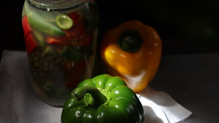 Fermeted pickled peppers in the glass jar with dark background and copy space