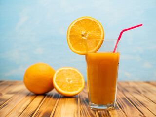 Orange juice in a glass with a slice of orange and an straw.