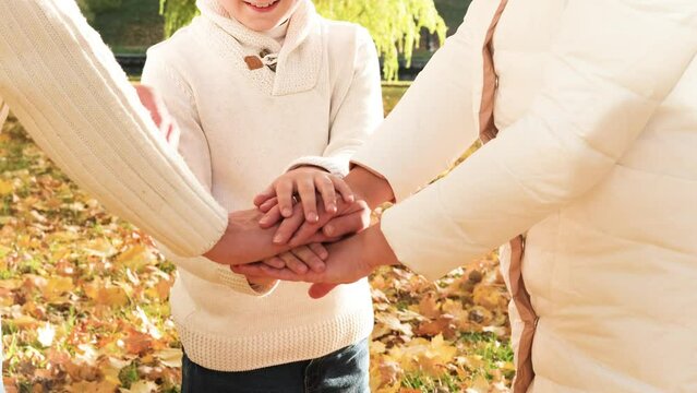 Close up of three Caucasian person stack their palms. Father, mother and son holding their hands together. Gesture sign of support and love, unity togetherness relative people concept. 