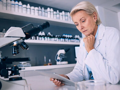 Science, tablet and thinking with woman in laboratory for research, medical and pharmacy. Medicine, healthcare and digital report with mature scientist reading online for email, data and results