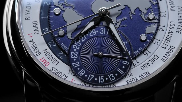 satin on watch face. time zones and countries on the watch face. Extreme closeup of second arrow passing by on blue clock face. Lengthwise view of luxury swiss watch. Closeup real time shot. 