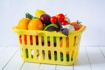 Fresh ripe vegetables in a yellow basket