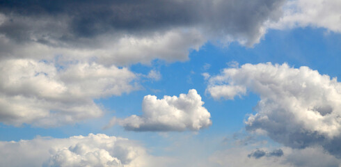 Fototapeta na wymiar White cumulus clouds among dark rain clouds