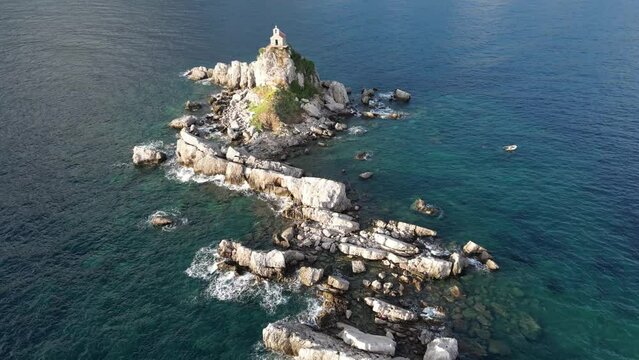 Church on the rock on Katic islet in Petrovac na Moru Aerial View. Beaches and coastline of the Adriatic Sea at summer time. Natural landscapes of Montenegro. Balkans. Europe.