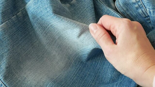 woman hands takes jeans jackets with pockets, denim fashion