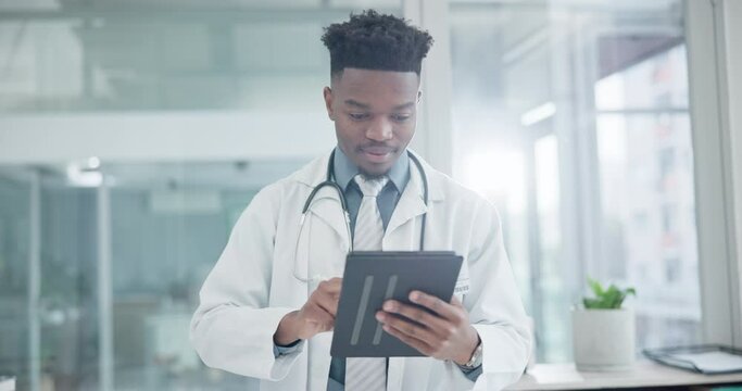 Medical, tablet and a doctor black man in the hospital for research or health in modern treatment. Healthcare, technology and information with a happy medicine professional in a clinic for innovation