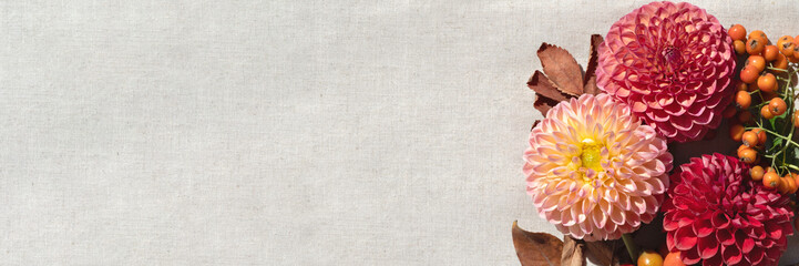 Autumn floral banner, template for business brand marketing advertising. Bouquet with red, pink dahlia flower, orange berries, brown fall leaves on neutral beige blurred linen cloth background