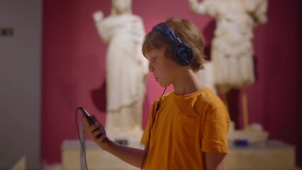 Little boy is portrayed exploring a history museum, attentively listening to an audio guide. The camera captures his inquisitive expressions and genuine interest as he immerses himself in the exhibits