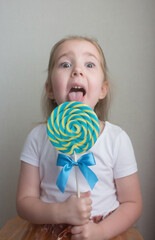 Little girl holding a big lollipop in her hands