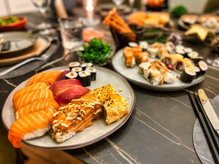 a dish on a festivily decorated table with japanese sushi rolls with raw fish