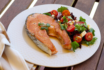Fried salmon steak with salad