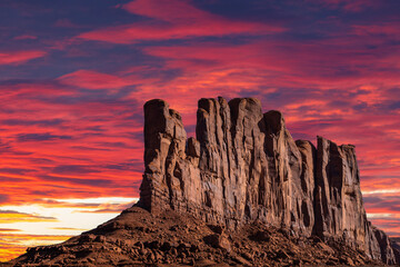 Classic southwest desert landscape under an evening sky and bright sun in Monument Valley in Arizona and Utah.