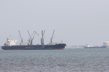 Fototapeta premium Huge industrial oil-producing vessel sails on a river