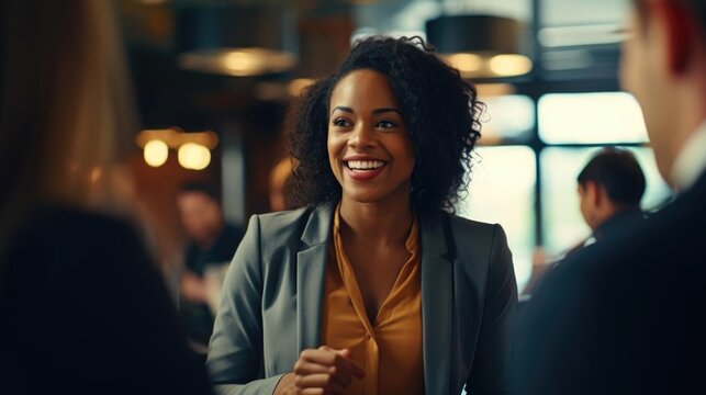 Smiling black female entrepreneur talking to her colleagues