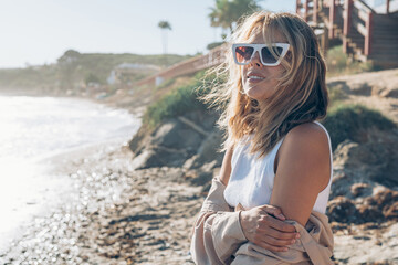 Fototapeta na wymiar portraits of a girl in glasses with a smile on the seashore