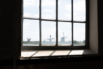 View of water management 
 windmills through pumping station glass window at UNESCO world heritage site Kinderdijk in Holland. Dutch historic centre 