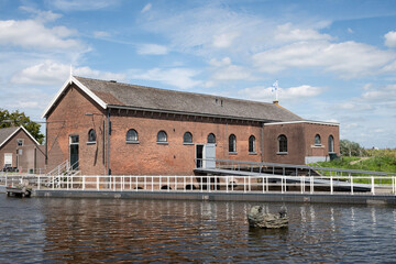 Fototapeta na wymiar Old Wisboom pumping station in Kinderdjk Netherlands. Red brick industrial building housed steam then electric powered pumps that replaced the traditional windmills at UNESCO world heritage site