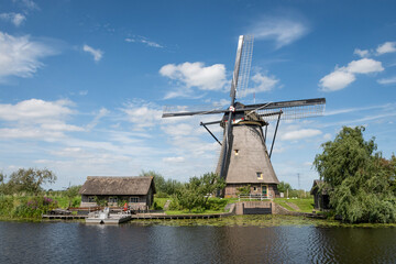 iconic smock ground sailer windmill in Kinderdijk Netherlands. Landmark buildings originally made to pump water out of low land polder to preserve land reclaimed from the sea - obrazy, fototapety, plakaty