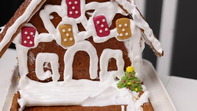 siblings boys doing with granny gingerbread christmas house.preschooler child wearing toque chef  hat,apron,mixing cream,licking from wires beaters.toddler with tree headband,modern kitchen 4k
