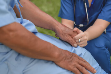 Female Doctor Touching Hand of the Senior Patient to Give Encouragement while Maintaining Physical Health Rehabilitation. Science of Touch. Selective Focus on Hands.