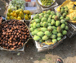 Traders at the market are selling various fresh fruits and vegetables