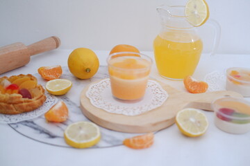 Fresh orange juice in a glass with fresh fruits on a white background