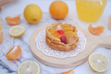 Homemade lemon tart with fresh fruit and orange juice on white background