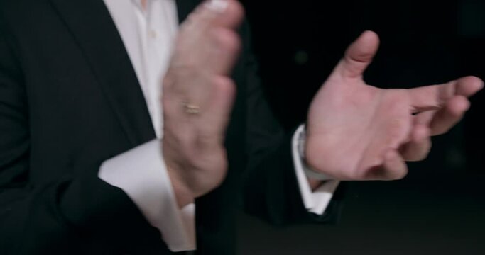 young businessman in elegant black suit and white shirt , clapping hands, celebrating successful project on black background Slow motion Congratulation Actor, emploee, performer applauding at meeting