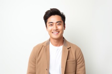 Lifestyle portrait of a Chinese man in his 20s in a white background wearing a chic cardigan