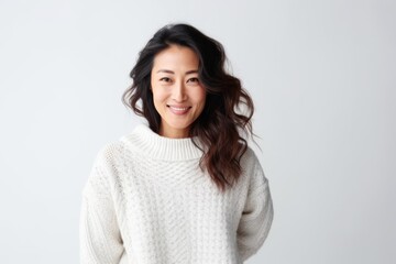 Obraz premium Medium shot portrait of a Chinese woman in her 30s in a white background wearing a cozy sweater